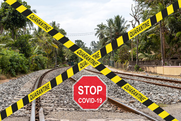 ''Stop COVID-19'' road sign and crossed quarantine warning tapes against railways