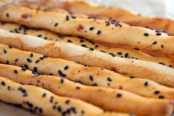 Traditional italian grissini bread sticks with black sesame seeds. National cuisine of Italy. Close-up.