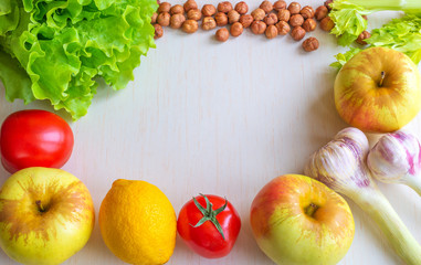 Keto diet. Tomatoes, lemon, garlic, apples, lettuce and nuts lie on a light wooden background. Flat flat, top view, copy space