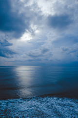 Fototapeta premium Waves and clouds. Blue ocean Beautiful sunset at Balangan Beach on the island of Bali in Indonesia. Surfers catch the waves, tourists relax and enjoy the sunset or sunrise