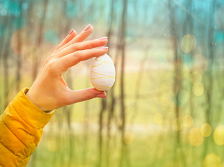 female hand holds colorful easter eggs, bright easter background