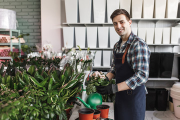 Portrait of  garnener man with flower  taking it out of brown pot,  hydration, moisturized, plants care