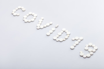 Covid-19 inscription made of round white tablets on a white background, medical concept on the theme of the coronavirus pandemic with copy spce.