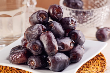 Ramadan iftar food delicious date fruits and water on wooden plate.