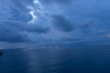 Beautiful blue sunset on the ocean with big waves and cliffs and cliffs. Bali island with its tropical and exotic nature. Sunrise over the sea and ocean. Phantom blue in sunset