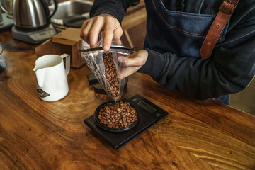 Fototapeta na wymiar Barista weighs coffee beans, close up photo