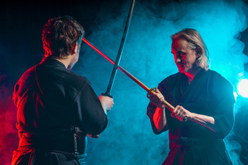 two kendo fighters practicing kenjutsu, Japanese martial art using samurai swords. people combat fighting