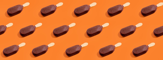 Ice cream chocolate popsicles pattern on trendy vivid orange background