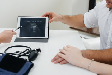 A close - up image of the baby's ultrasound on the tablet, during a consultation with a doctor. Medicine