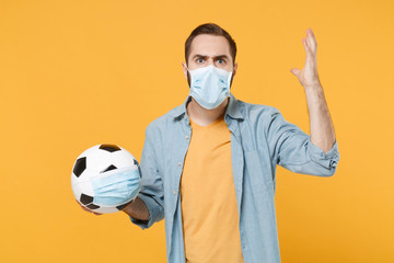 Angry man in face mask isolated on yellow background. Epidemic pandemic 2019-ncov sars covid-19 flu...