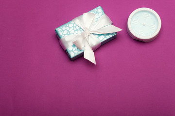 Alarm Clock And Gift Box isolated purple background