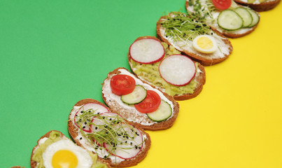  Sandwiches with healthy vegetables, tomatoes, eggs, micro greens on plate on colorful background. Healthy food concept.