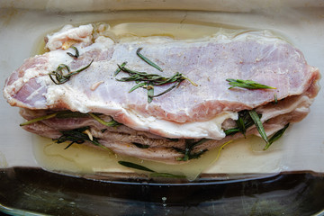 Raw fat pork meat seasoned with salt, papper, garlic and rosemary branches