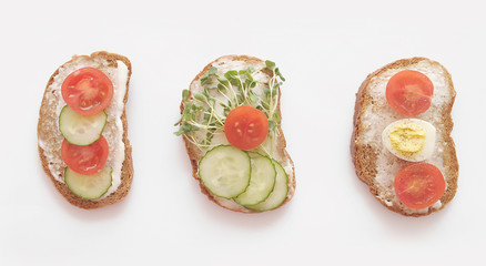 Healtht sandwiches with vegetables and micro greens on white background.