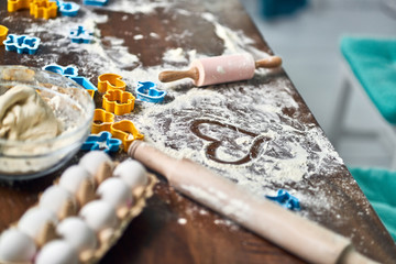 Dough, eggs, rolling pin, and other baking items on the kitchen table. From bakery with love