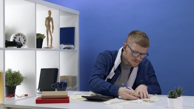 Caucasian bearded man considers expenses and plans a budget. Cash receipts are scattered across the table. Marks with a pencil. Loans, mortgages and cash debts. Financial difficulties concept.