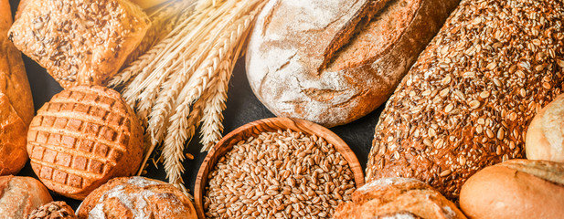 Various kind of bread with wheat top view. White bakery food concept panorama or wide banner photo.