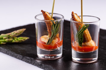 Snacks with dessert corn and tomato sauce with greens in shots on a black background
