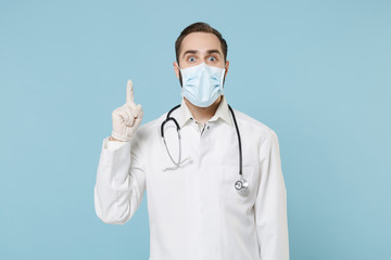 Male doctor man in white medical gown sterile face mask gloves isolated on blue background....