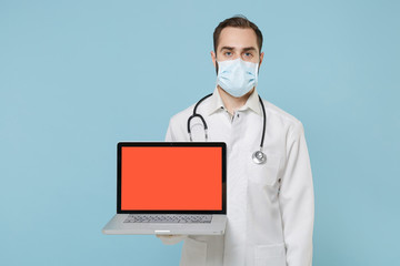 Male online doctor man in medical gown face mask gloves isolated on blue background. Epidemic...