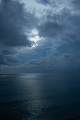Fototapeta premium Beautiful blue sunset on the ocean with big waves and cliffs and cliffs. Bali island with its tropical and exotic nature. Sunrise over the sea and ocean. Phantom blue in sunset