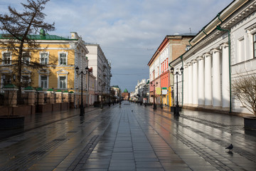 Bolshaya Pokrovskaya street in Nizhny Novgorod without people after rain with reflections of buildings on the paving stones in the rays of the spring sun