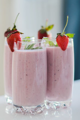 Closeup of strawberry fruit smoothies with strawberry pieces in glass