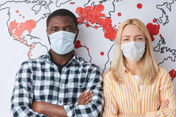 portrait of two diverse people in medical masks, global pandemic coronavirus, COVID-19 infection...