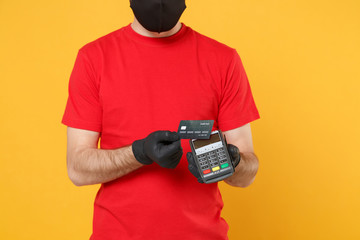 Delivery man in red cap blank t-shirt sterile mask gloves isolated on yellow background studio Guy employee hold bank payment terminal Service quarantine pandemic coronavirus virus 2019-ncov concept.