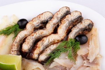 Fish plate with red fish, canned food and halibut, served with lime and dill and olives