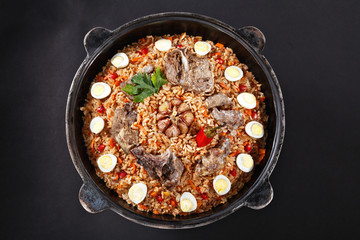 High quality photo of famous dish PILAF. Traditional Uzbek PLOV. Black background. Flat lay. Lamb...