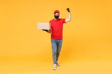 Delivery man employee in red cap blank t-shirt uniform face mask glove hold empty cardboard box isolated on yellow background studio Service quarantine pandemic coronavirus flu virus 2019-ncov concept