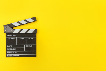 Filmmaker profession. Classic director empty film making clapperboard or movie slate isolated on yellow background. Video production film cinema industry concept. Flat lay top view copy space mock up. - obrazy, fototapety, plakaty