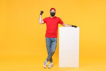 Delivery man in red cap t-shirt uniform sterile face mask gloves hold blank sign board isolated on...