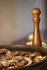 Healthy sea food, fresh Oysters with pepper gourmet close-up on white and black plate served in a restaurant