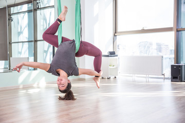 Photo of young woman practicing yoga indoor. Beautiful girl practice yoga in class. Yoga studio instructor. Blurred background.