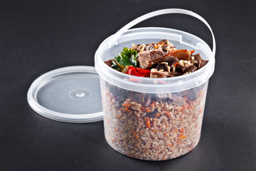 Traditional Uzbek pilaf in delivery one-time plastic dish. 1 kg national plov.