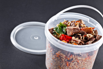 Traditional Uzbek pilaf in delivery one-time plastic dish. 1 kg national plov.