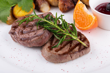 Grilled steak, served with potatoes in mundiers and blackcurrant sauce