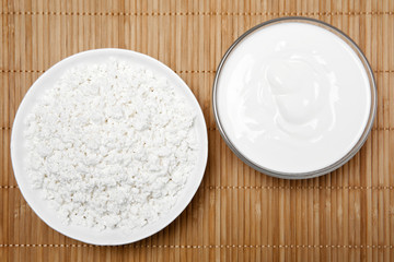 bowls with cottage cheese and sour cream on the table, top view