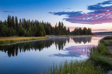 The morning sky erupts in color above the Snake River in Grand Teton National Park.