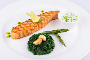 Grilled trout steak, served with lime, garlic sauce and asparagus