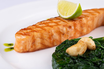 Grilled trout steak, served with lime, garlic sauce and asparagus