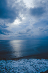 Beautiful blue sunset on the ocean with big waves and cliffs and cliffs. Bali island with its tropical and exotic nature. Sunrise over the sea and ocean. Phantom blue in sunset