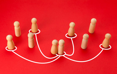 Obraz premium Concept of infidelity and betrayal (treason) in family or married couple. Wooden figures with lines as symbol of the relationship between man and woman on red background.
