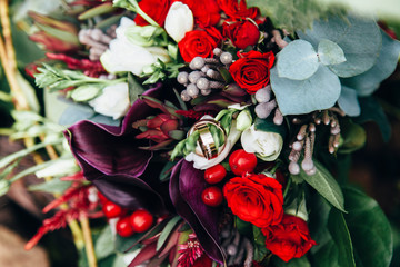 Fototapeta premium Wedding rings lie in the bride's wedding bouquet