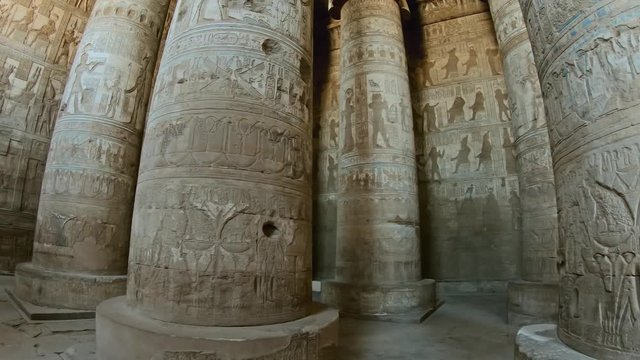 Interior of the painted and carved hypostyle hall at Dendera Temple. Ancient Egyptian temple near Qena. Pan view 4k