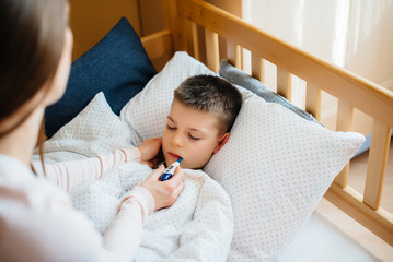 A mother takes care of her child who has a fever and fever. Disease and healthcare
