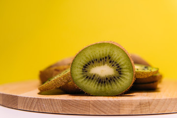 Kiwi fruit in a cut close-up on a yellow background with a place for text side view