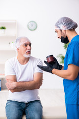 Obraz premium Old man visiting male doctor for plastic surgery